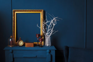 Blue wall with blue furniture and a gold picture frame
